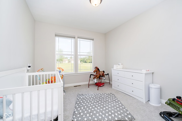 carpeted bedroom featuring a crib