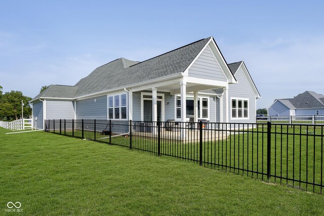 rear view of property featuring a lawn