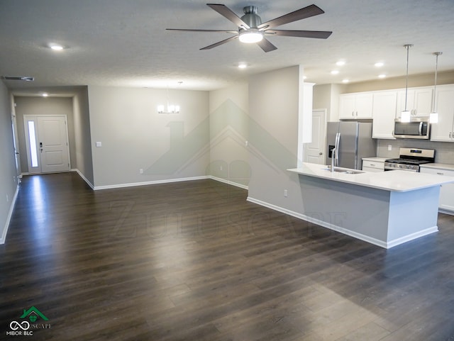 kitchen featuring appliances with stainless steel finishes, pendant lighting, white cabinetry, and dark hardwood / wood-style floors