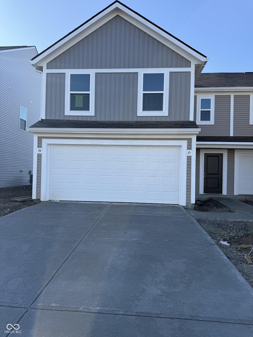 traditional-style home featuring driveway and board and batten siding