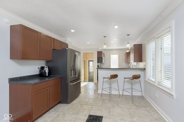 kitchen featuring stainless steel refrigerator with ice dispenser, pendant lighting, a healthy amount of sunlight, and light tile patterned floors