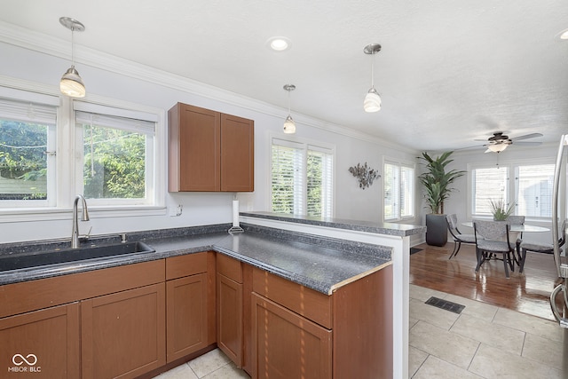 kitchen featuring pendant lighting, sink, ceiling fan, and light hardwood / wood-style floors