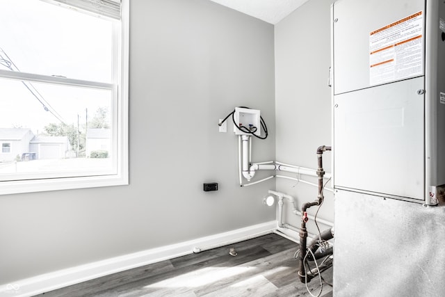 clothes washing area with washer hookup, baseboards, and wood finished floors