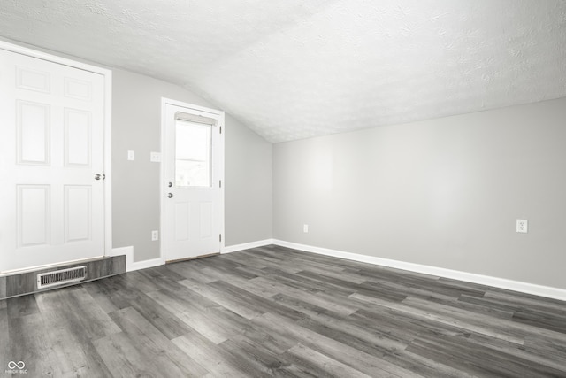 bonus room with baseboards, visible vents, dark wood-style floors, vaulted ceiling, and a textured ceiling