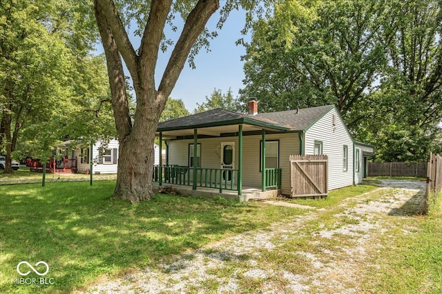 view of front of house with covered porch and a front lawn