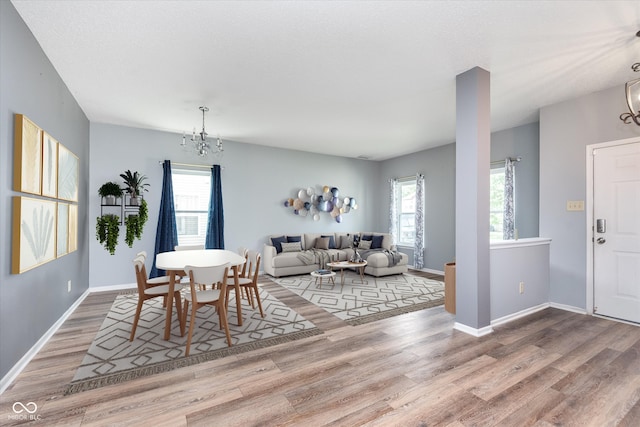 dining space with plenty of natural light, wood finished floors, and baseboards