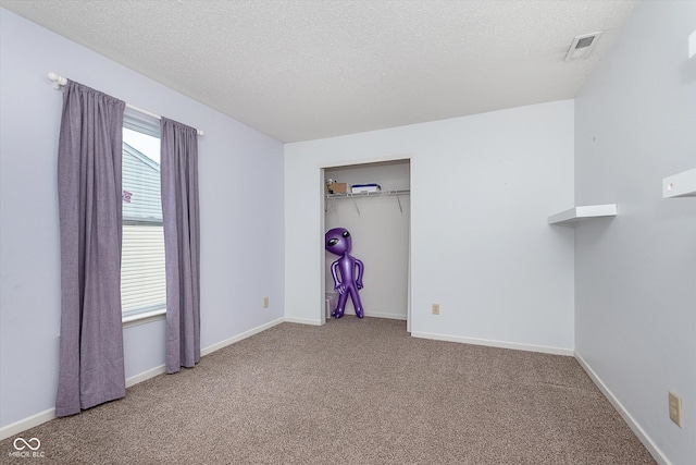 unfurnished bedroom with carpet, a closet, visible vents, a textured ceiling, and baseboards