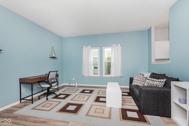 office space featuring a textured ceiling, wood finished floors, and baseboards