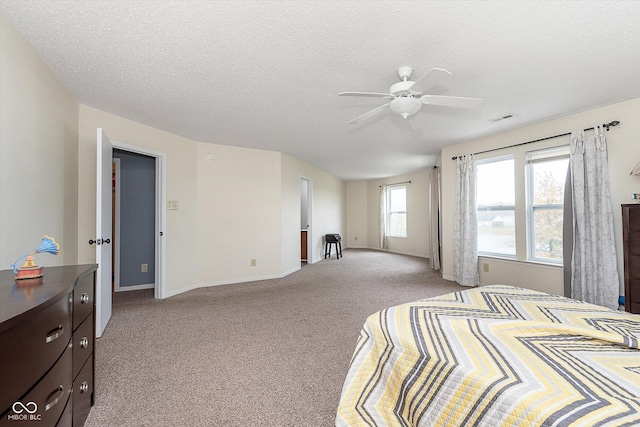 bedroom featuring a textured ceiling, ceiling fan, carpet flooring, and visible vents