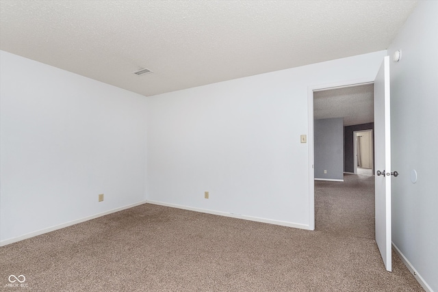 unfurnished room featuring carpet floors, visible vents, a textured ceiling, and baseboards