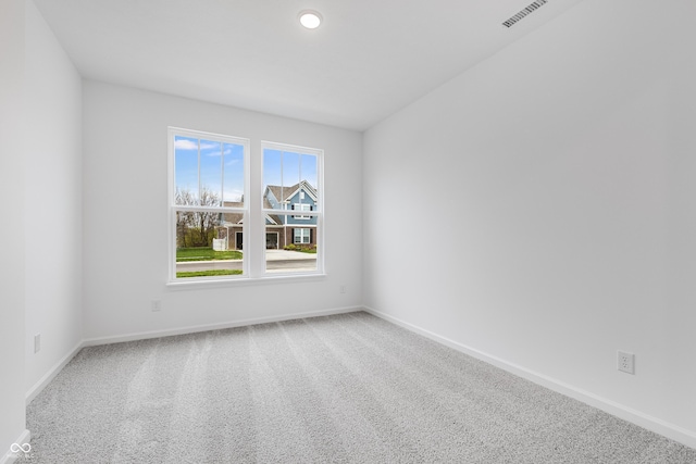 spare room with baseboards, visible vents, and carpet