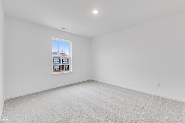 carpeted spare room with baseboards and visible vents