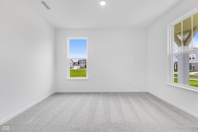 carpeted empty room featuring baseboards, visible vents, and recessed lighting