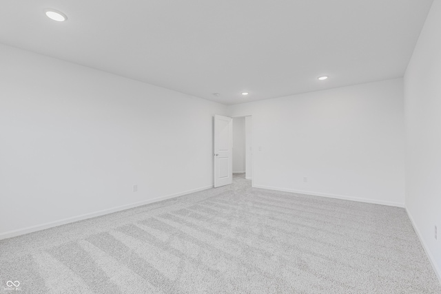 unfurnished room featuring baseboards, recessed lighting, and light colored carpet