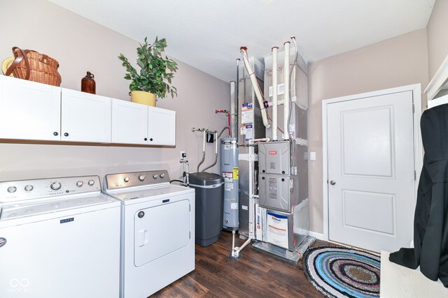 washroom featuring washing machine and dryer, cabinets, dark hardwood / wood-style floors, heating unit, and electric water heater