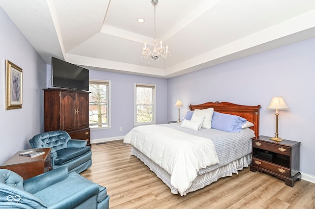 14626 Warner Trl, Westfield, IN 46074 - bedroom with a tray ceiling, baseboards, light wood-style flooring, and a chandelier