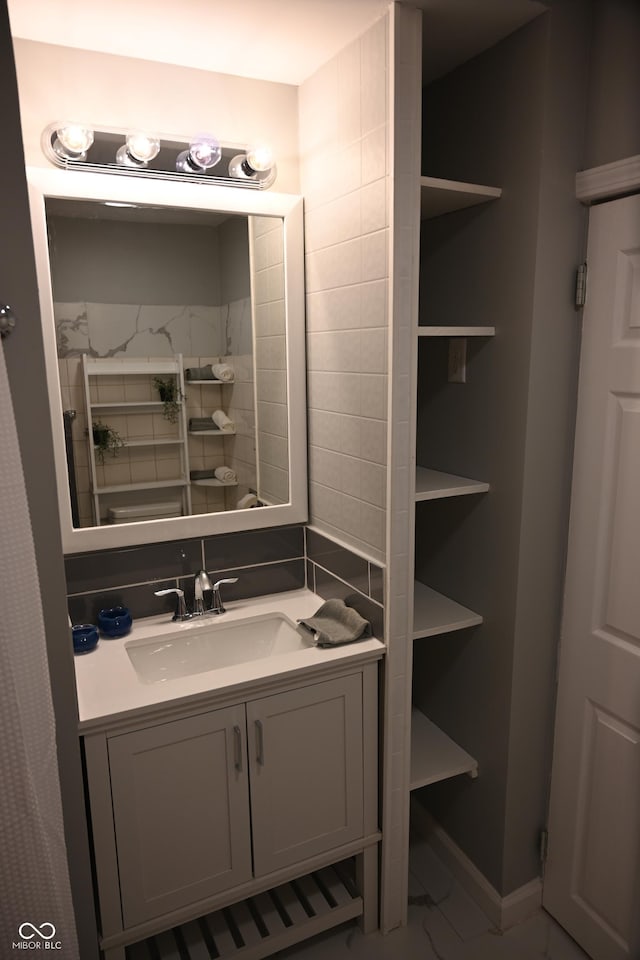 bathroom featuring marble finish floor, vanity, and baseboards