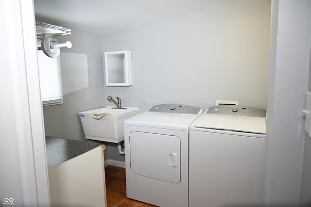 washroom with laundry area, dark tile patterned floors, a sink, and washer and dryer