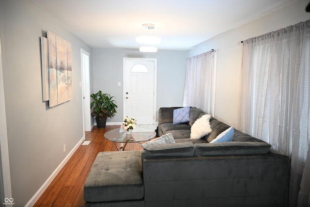 living area featuring baseboards and wood finished floors