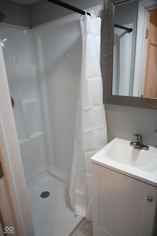 bathroom with a stall shower, tile patterned flooring, and vanity