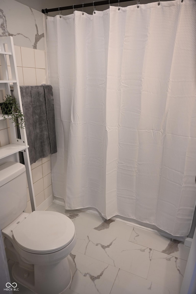 full bath featuring marble finish floor and toilet