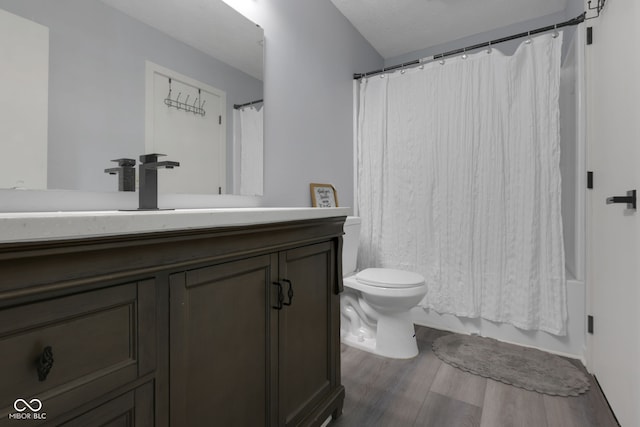 full bathroom with shower / bath combo with shower curtain, hardwood / wood-style flooring, vanity, and toilet