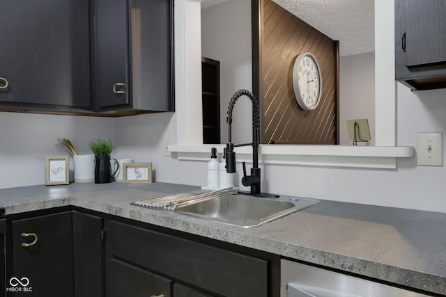 kitchen featuring a textured ceiling, dishwasher, and sink