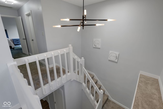 stairway featuring a chandelier and carpet flooring