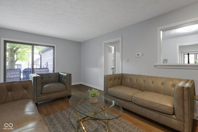 living room featuring a textured ceiling and dark wood-type flooring