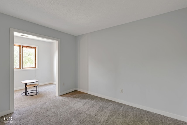 carpeted spare room featuring a textured ceiling