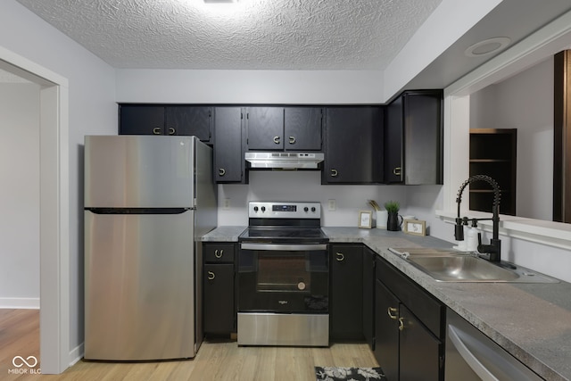 kitchen featuring a textured ceiling, light hardwood / wood-style floors, sink, and stainless steel appliances