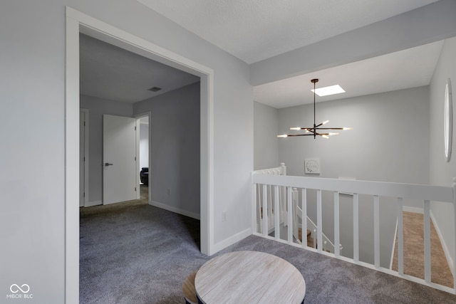 hallway featuring carpet and an inviting chandelier