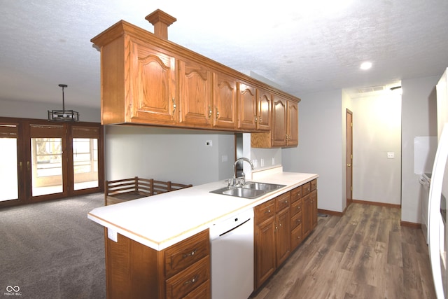 kitchen with a textured ceiling, dishwasher, dark hardwood / wood-style flooring, and sink