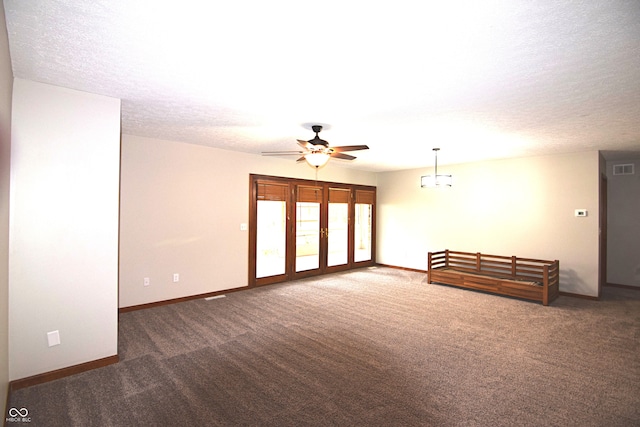 unfurnished room featuring ceiling fan, a textured ceiling, and dark colored carpet