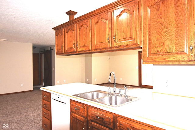 kitchen featuring dishwasher, a barn door, dark colored carpet, and sink