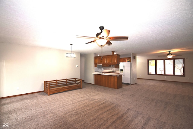 unfurnished living room featuring ceiling fan, sink, carpet floors, and a textured ceiling