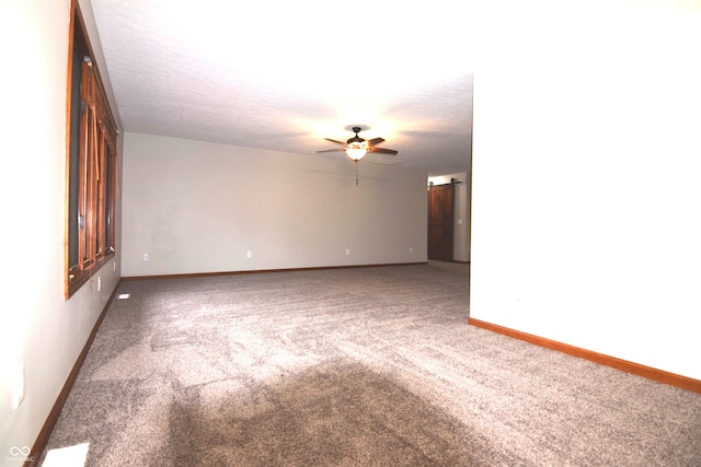 carpeted spare room with ceiling fan and a textured ceiling