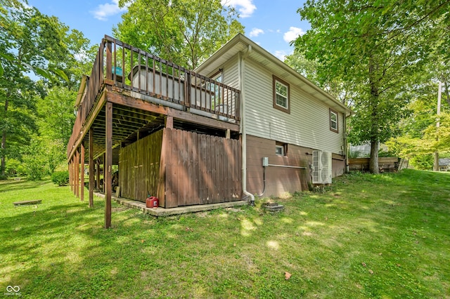 back of house featuring a deck and a lawn