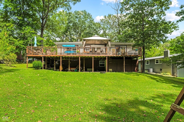 rear view of house with a lawn and a deck