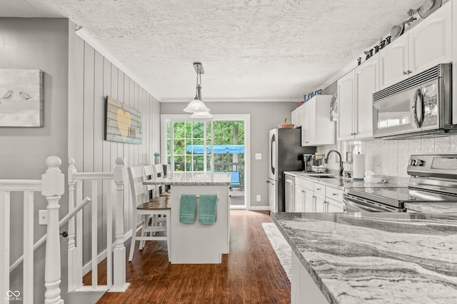 kitchen with sink, appliances with stainless steel finishes, light stone countertops, dark hardwood / wood-style floors, and white cabinets