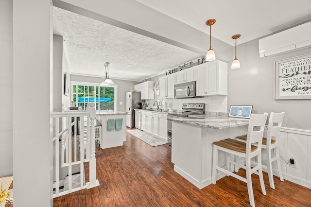 kitchen featuring white cabinetry, stainless steel appliances, dark wood-type flooring, and pendant lighting