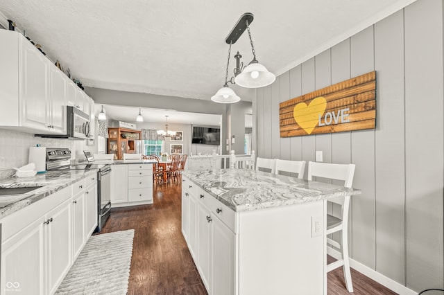 kitchen featuring a kitchen island, electric range oven, dark wood-type flooring, and white cabinets