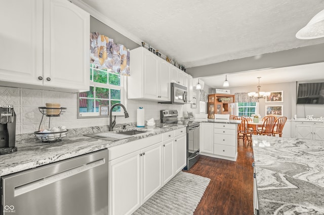 kitchen featuring plenty of natural light, dark wood-type flooring, light stone countertops, and stainless steel appliances