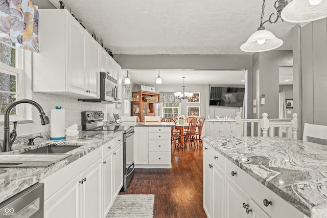 kitchen featuring a wealth of natural light, stainless steel appliances, white cabinets, and sink