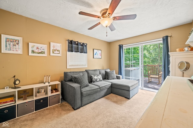 living room with ceiling fan, light carpet, and a textured ceiling