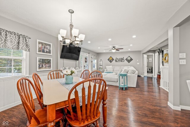 dining room with ceiling fan with notable chandelier and dark hardwood / wood-style floors