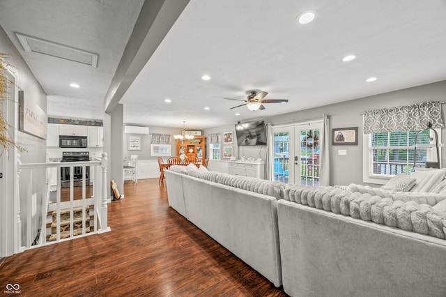 living room featuring ceiling fan with notable chandelier, dark hardwood / wood-style floors, and french doors