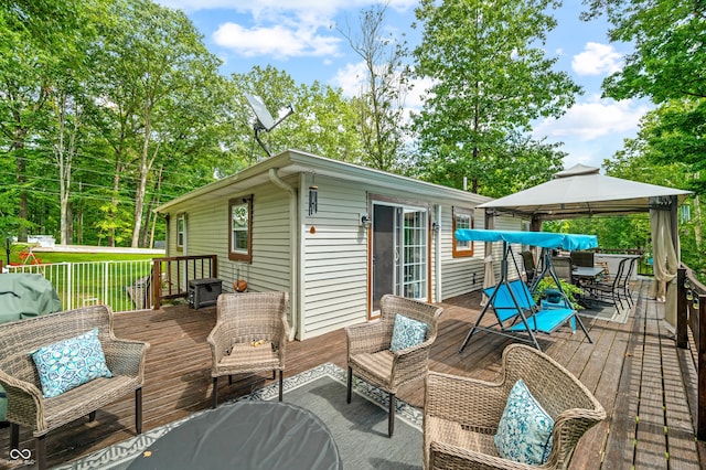 wooden deck featuring an outdoor living space and a gazebo