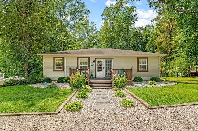 view of front facade featuring a wooden deck and a front yard