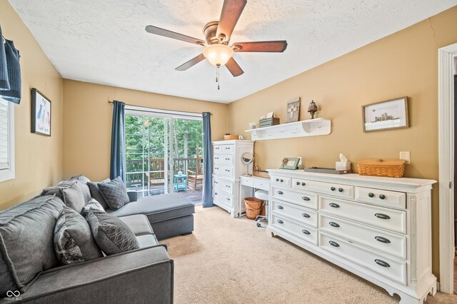 carpeted living room with ceiling fan and a textured ceiling